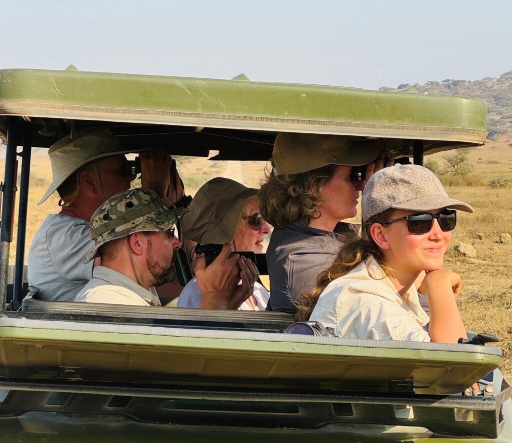Reisegruppe beobachtet Tiere aus dem offenen Safari-Geländewagen